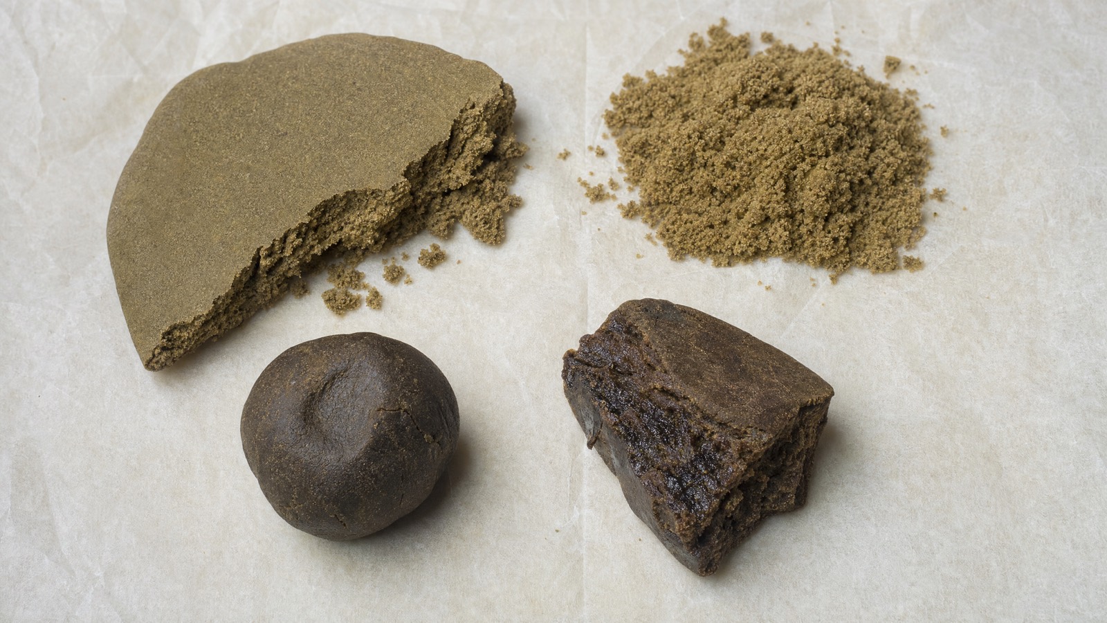 Four hash textures on parchment: a broken resin chunk, golden kief, a dark pressed ball and a crumbly piece